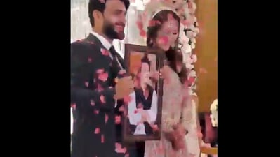 Snapshot of the bride and groom with a picture of Imran Khan. Snapshot of the bride and groom with a picture of Imran Khan.
