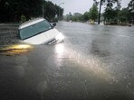 An SUV stranded in a ditch in a stretch of street flooding during a severe storm in Texas. 