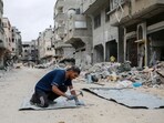 A Palestinian man fixes tin sheets used for temporary sheltering on a road lined with destroyed buildings in Khan Yunis in the southern Gaza Strip on May 2, 2024, amid the ongoing conflict between Israel and the Hamas movement. A Palestinian man fixes tin sheets used for temporary sheltering on a road lined with destroyed buildings in Khan Yunis in the southern Gaza Strip on May 2, 2024, amid the ongoing conflict between Israel and the Hamas movement.