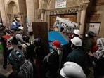 Protesters reinforce the barricades set up against one of the doors of Royce Hall as police started clearing a pro-Palestinian encampment on the campus of the University of California, Los Angeles (UCLA) in Los Angeles, California, early on May 2, 2024. Hundreds of police tore down protest barricades and began arresting students early Thursday at the University of California, Los Angeles �- the latest flashpoint in an eruption of protest on US campuses over Israel's war against Hamas in Gaza. (Photo by ETIENNE LAURENT / AFP) Protesters reinforce the barricades set up against one of the doors of Royce Hall as police started clearing a pro-Palestinian encampment on the campus of the University of California, Los Angeles (UCLA) in Los Angeles, California, early on May 2, 2024. Hundreds of police tore down protest barricades and began arresting students early Thursday at the University of California, Los Angeles �- the latest flashpoint in an eruption of protest on US campuses over Israel's war against Hamas in Gaza. (Photo by ETIENNE LAURENT / AFP)