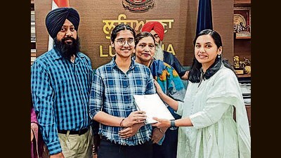 Deputy commissioner Sakshi Sawhney felicitating a student of Class 12 in Ludhiana on Thursday. (HT Photo)