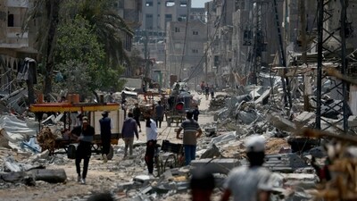 Graphic content / Palestinians walk amid the rubble of destroyed buildings in Nuseirat, in the central Gaza (AFP) Graphic content / Palestinians walk amid the rubble of destroyed buildings in Nuseirat, in the central Gaza (AFP)