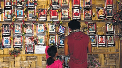 People look at photographs of those who they say have died in ethnic violence at a wall of remembrance in Manipur. (REUTERS) People look at photographs of those who they say have died in ethnic violence at a wall of remembrance in Manipur. (REUTERS)