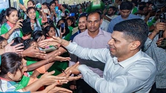 VK Pandian shakes hands with students during a programme in Bhubaneshwar. (ANI)
