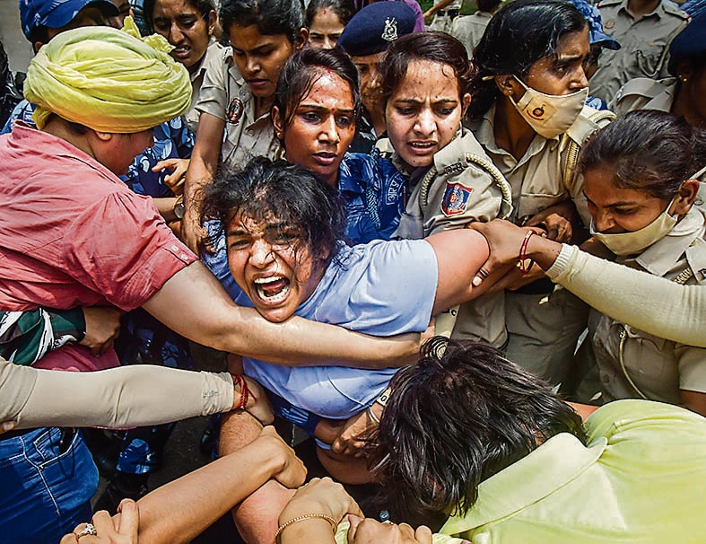 Security personnel detain wrestler Sakshi Malik during a protest march towards new Parliament building on May 28, 2023. (PTI) Security personnel detain wrestler Sakshi Malik during a protest march towards new Parliament building on May 28, 2023. (PTI)