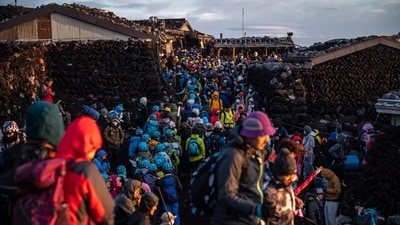 People gather after watching the sunrise from the summit of Mount Fuji, some 70 kilometres (43 miles) west of the capital Tokyo. Japanese authorities are gearing up to impose crowd control measures for the first time on Mount Fuji this weekend for an expected holiday rush by thousands of sometimes ill-prepared trekkers. (Photo by Philip FONG / AFP) People gather after watching the sunrise from the summit of Mount Fuji, some 70 kilometres (43 miles) west of the capital Tokyo. Japanese authorities are gearing up to impose crowd control measures for the first time on Mount Fuji this weekend for an expected holiday rush by thousands of sometimes ill-prepared trekkers. (Photo by Philip FONG / AFP)