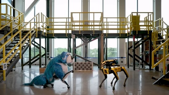 The image shows two Spot robot dogs by Boston Dynamics, with one of them in a blue-coloured costume. It’s called Sparkles. (YouTube/@BostonDynamics)