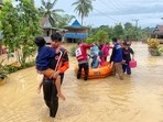 Rescuers carry people affected by a flood in Wajo, South Sulawesi, Indonesia. Rescuers carry people affected by a flood in Wajo, South Sulawesi, Indonesia.
