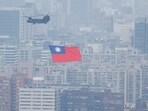 China-Taiwan Conflict: A Chinook helicopter carrying a Taiwan flag flies over the city during the country's National Day celebration in Taipei, Taiwan.
