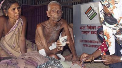 An election official marks the finger of an elderly voter as he casts his vote from his home through postal ballot for the Lok Sabha elections at Gazole in West Bengal’s Malda district on Friday. (PTI) An election official marks the finger of an elderly voter as he casts his vote from his home through postal ballot for the Lok Sabha elections at Gazole in West Bengal’s Malda district on Friday. (PTI)