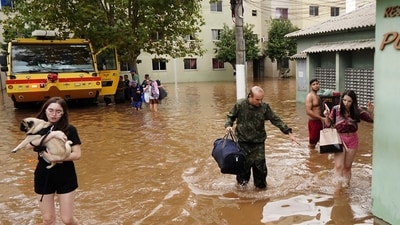 Residents evacuate from a neighborhood flooded by heavy rains, in Canoas, Rio Grande do Sul state, Brazil. (AP) Residents evacuate from a neighborhood flooded by heavy rains, in Canoas, Rio Grande do Sul state, Brazil. (AP)