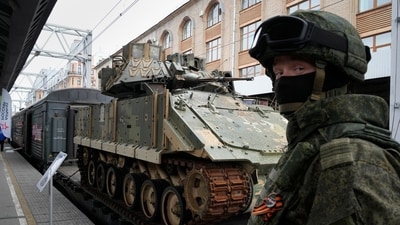 A Russian soldier stands guard near a M2 Bradley fighting vehicle captured from Kyiv forces during the fighting in Ukraine, loaded on platform of an agit-train during an event to promote the Russian military operation in Ukraine at the Moskovsky railway station in St. Petersburg, Russia, Saturday, May 4, 2024. (AP Photo/Dmitri Lovetsky) (AP)