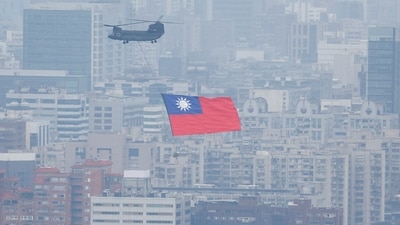 China-Taiwan Conflict: A Chinook helicopter carrying a Taiwan flag flies over the city during the country's National Day celebration in Taipei, Taiwan. (Reuters)