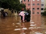 A man, carrying a baby, wades through a street flooded by heavy rains, in Canoas, Rio Grande do Sul state, Brazil. A man, carrying a baby, wades through a street flooded by heavy rains, in Canoas, Rio Grande do Sul state, Brazil.