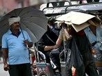 A man (L) takes shelter under an umbrella from the scorching sun on a hot summer afternoon A man (L) takes shelter under an umbrella from the scorching sun on a hot summer afternoon