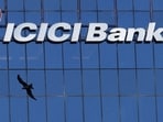 A bird flies past the facade of the ICICI bank head office in Mumbai.