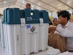 Polling officials collect VVPATs and other voting materials ahead of the Karnataka assembly elections, at Veterinary College distribution centre in Bengaluru on Tuesday. (PTI)