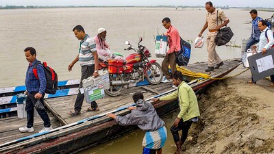 Polling officials get on a boat to reach their respective polling booths in Kamrup, Assam. (PTI) Polling officials get on a boat to reach their respective polling booths in Kamrup, Assam. (PTI)