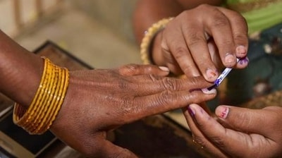 An election officer puts an indelible ink mark on the finger of a voter. (PTI) An election officer puts an indelible ink mark on the finger of a voter. (PTI)