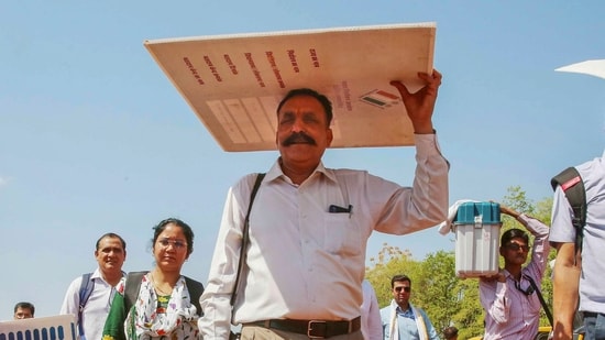 Polling officials carrying election material leave for their duty during in a hot day in Bhopal, Madhya Pradesh.(PTI)