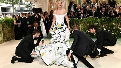 Gigi Hadid turned heads at the Met Gala in a white off-the-shoulder corset dress with exaggerated hips, paired with a white silk moiré coat adorned with black duchesse satin tipping and 3D yellow roses. (Evan Agostini/Invision/AP) Gigi Hadid turned heads at the Met Gala in a white off-the-shoulder corset dress with exaggerated hips, paired with a white silk moiré coat adorned with black duchesse satin tipping and 3D yellow roses. (Evan Agostini/Invision/AP)