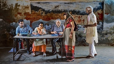 A polling official checks the name of a woman before allowing her to cast her vote during the third round of voting in the six-week-long general election in Agra on Tuesday. (AP)