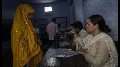 A polling official compares the photograph of a woman with her identity card before allowing her to cast her vote during the third round of voting in the six-week-long general election, in Agra on Tuesday. (AP Photo) A polling official compares the photograph of a woman with her identity card before allowing her to cast her vote during the third round of voting in the six-week-long general election, in Agra on Tuesday. (AP Photo)