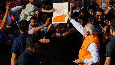 PM Narendra Modi gives back a painting of him to a girl after signing on it on the day he votes during the third phase of the general election in Ahmedabad. (REUTERS)