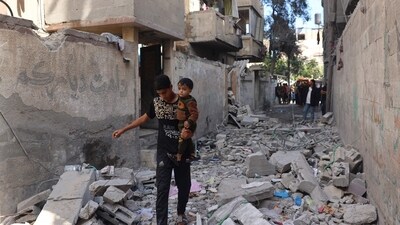 Palestinian youth carries a child as he walks through the rubble following Israeli bombardment of Rafah's Tal al-Sultan district in the southern Gaza Strip on May 7, 2024. The Israeli army said it took "operational control" of the Palestinian side of the Rafah border crossing between Gaza and Egypt on May 7 and that troops were scanning the area. (Photo by AFP) (AFP) Palestinian youth carries a child as he walks through the rubble following Israeli bombardment of Rafah's Tal al-Sultan district in the southern Gaza Strip on May 7, 2024. The Israeli army said it took "operational control" of the Palestinian side of the Rafah border crossing between Gaza and Egypt on May 7 and that troops were scanning the area. (Photo by AFP) (AFP)