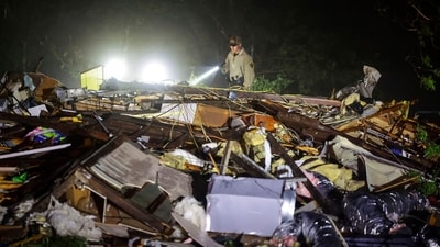 An Oklahoma State Highway Patrol trooper searches storm damage Tuesday, May 7, 2024 in Barnsdall, Okla. (Mike Simons/Tulsa World via AP) (AP) An Oklahoma State Highway Patrol trooper searches storm damage Tuesday, May 7, 2024 in Barnsdall, Okla. (Mike Simons/Tulsa World via AP) (AP)