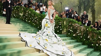 Gigi Hadid's Met Gala look sounds absolutely stunning! Thom Browne is known for his avant-garde designs, and it seems like she embodied the aesthetic perfectly with the white off-the-shoulder corset dress and the exaggerated hips, which add a touch of drama. The layering of the white silk moiré coat with black duchesse satin tipping, adorned with 3D yellow roses, sounds intricate and elegant. (AFP) Gigi Hadid's Met Gala look sounds absolutely stunning! Thom Browne is known for his avant-garde designs, and it seems like she embodied the aesthetic perfectly with the white off-the-shoulder corset dress and the exaggerated hips, which add a touch of drama. The layering of the white silk moiré coat with black duchesse satin tipping, adorned with 3D yellow roses, sounds intricate and elegant. (AFP)