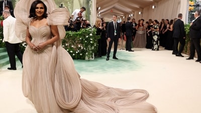 Mindy Kaling captivated all in a voluminous, nude-coloured strapless gown by Gaurav Gupta at Met Gala 2024. The gown featured sculptural elements that arced over her head and cascaded down her back in a striking pattern of loops and swirls. With an enormous train, Kaling required multiple handlers to assist her in carrying it as she gracefully walked down the red carpet. (REUTERS)