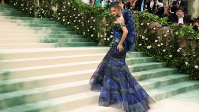 For Met Gala 2024, Zendaya dazzled in a Maison Margiela by John Galliano gown, inspired by a 1994 Dior design. Styled by Law Roach, she donned the stunning bottle green and blue jewel-toned ensemble, featuring a dramatic flair and black fascinator on her head with a green net layer in front. (REUTERS)
