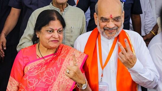 Union Home Minister Amit Shah with wife Sonal Shah shows his ink-marked finger after casting vote for Lok Sabha elections in Ahmedabad.(PTI)