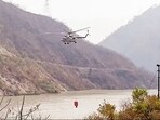 Indian Air Force's helicopter fills Bambi Bucket to douse the raging forest fire in the forests of Advani by taking water from the Alaknanda River in Srinagar. 