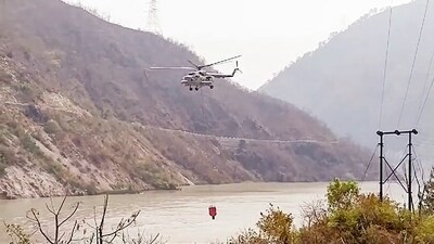 Indian Air Force's helicopter fills Bambi Bucket to douse the raging forest fire in the forests of Advani by taking water from the Alaknanda River in Srinagar. (ANI) Indian Air Force's helicopter fills Bambi Bucket to douse the raging forest fire in the forests of Advani by taking water from the Alaknanda River in Srinagar. (ANI)