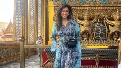Here, she is seen at a Buddhist temple in a beautiful blue dress and a fanny pack. Here, she is seen at a Buddhist temple in a beautiful blue dress and a fanny pack. 