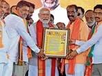 PM Narendra Modi being felicitated by BJP members during an election rally in Karimnagar district of Telangana on Wednesday. (ANI)(HT_PRINT)