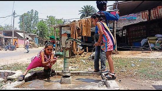 Children drawing water from a handpump at Makur village in Unnao Lok Sabha constituency. The water is invariably sandy. (Gaurav Saigal/HT Photo)
