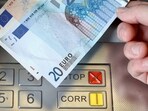 FILE PHOTO: A woman holds a 20 and 50 Euro bank notes in front of an ATM in this illustration picture taken in Bern January 16, 2015. REUTERS/Thomas Hodel/File Photo