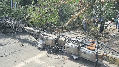 At least 15 vehicles were damaged, 80 trees and 30 electric poles were uprooted in different areas in Gurugram after a thunderstorm wreaked havoc in the city leaving a trail of destruction on Friday night. (Parveen Kumar/HT PHOTO)