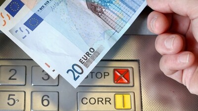 FILE PHOTO: A woman holds a 20 and 50 Euro bank notes in front of an ATM in this illustration picture taken in Bern January 16, 2015. REUTERS/Thomas Hodel/File Photo (REUTERS)