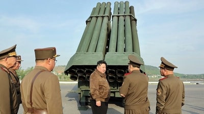 North Korean leader Kim Jong Un, center, supervises a test firing of a new multiple rocket launch system at an undisclosed place in North Korea (AP)