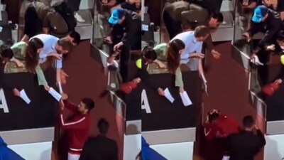 Novak Djokovic gets hit by a water bottle. Novak Djokovic gets hit by a water bottle.