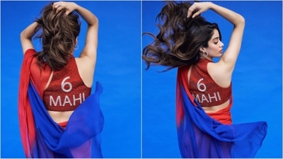 She paired her saree with a sleeveless red sequined blouse with a sweetheart neckline and a captivating '6 Mahi' written on the back, adding a glam factor and promoting her upcoming movie in style. (Instagram/@janhvikapoor) She paired her saree with a sleeveless red sequined blouse with a sweetheart neckline and a captivating '6 Mahi' written on the back, adding a glam factor and promoting her upcoming movie in style. (Instagram/@janhvikapoor)