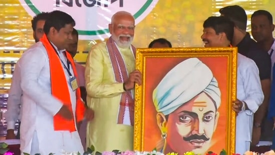 Prime Minister Narendra Modi being felicitated during a public meeting for Lok Sabha elections in Barrackpore, West Bengal on Sunday, (PTI)