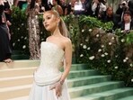 Pop sensation Ariana Grande graced the Met Gala 2024 red carpet, captivating all with her celestial-inspired ensemble. Designed by Loewe's creative director, Jonathan Anderson, her ethereal outfit boasts a sculpted bodice crafted entirely from mother of pearl, paired with a flowing white skirt adorned with floral eye decorations.