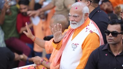 The Prime Minister is seen waving at the crowd cheering at him. A large number of women in saffron attire walked ahead of the vehicle carrying Modi. The group represented 'matrashakti'. (HT Photo/Rajesh Kumar) The Prime Minister is seen waving at the crowd cheering at him. A large number of women in saffron attire walked ahead of the vehicle carrying Modi. The group represented 'matrashakti'. (HT Photo/Rajesh Kumar)