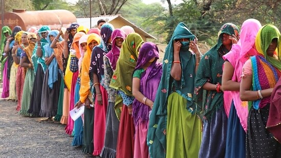 Women wait in a queue to cast their votes at a polling station in Jhabua district, Madhya Pradesh.(PTI)