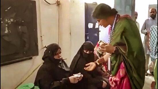 BJP candidate Madhavi Latha checks identity of voters at a polling station during the fourth phase of Lok Sabha elections in Hyderabad on Monday. (PTI)
